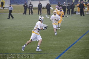 Junior Justin Klunder attempts to advance the play up the fi eld against the University at Albany. The Dragons are currently ranked No. 13 in the nation and will face Mount St. Mary’s University March 16.