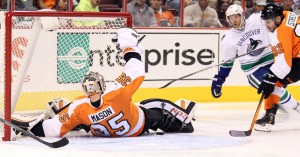 Philadelphia Flyers defenseman Mark Streit and Vancouver Canucks forward Jannik Hansen watch Flyers goalie Steve Mason stop the puck at the Wells Fargo Center in Philadelphia Oct. 15, 2013. The Flyers boast a record of 24-19-5, which puts them in second place tie in the Metropolitan Division with the New York Rangers.