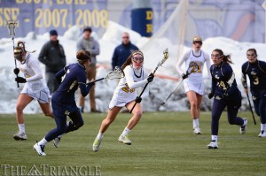 Sophomore midfielder Emily Duffey (center) makes a run versus George Washington University February 16, 2014. (Ken Chaney - The Triangle)