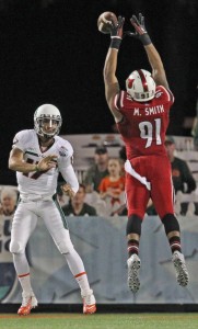 Miami quarterback Stephen Morris, left, has his pass deflected by Louisville's Marcus Smith (91) in the first quarter of the Russell Athletic Bowl at the Florida Citrus Bowl Stadium in Orlando, Fla., on Saturday, Dec. 28, 2013. (Al Diaz/Miami Herald/MCT)