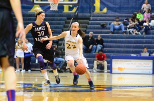 Point guard Meghan Creighton fends off a defender against James Madison University in a home game last season. (Ken Chaney - The Triangle)