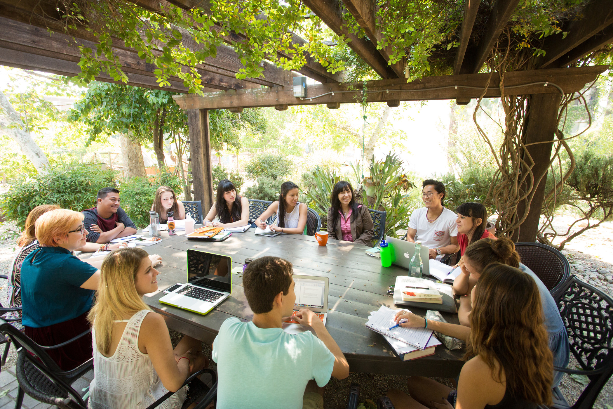 Roberta Espinoza, associate professor of sociology, with students in the outdoor classroom south of the Grove House.