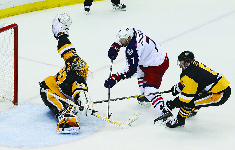 Pittsburgh Penguins goalie Marc-Andre Fleury (29) stops a shot from the Columbus Blue Jackets' Jack Johnson, middle, who gets behind the Penguins' Matt Cullen during the second period of Game 5 in the Eastern Conference quarterfinals at PPG Paints Arena in Pittsburgh on Thursday, April 20, 2017. The Penguins won, 5-2, to win the series 4-1. (Adam Cairns/Columbus Dispatch/TNS)